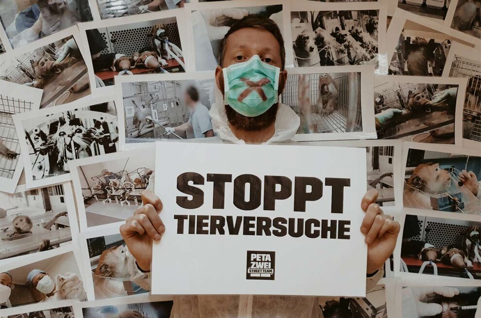 Man mit Schild Stoppt Tierversuche