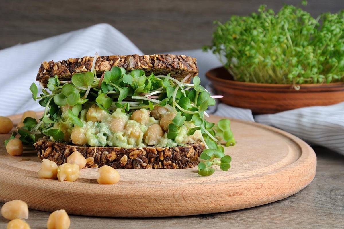 Avocado Kichererbsen Brot, serviert auf einem Holzteller.