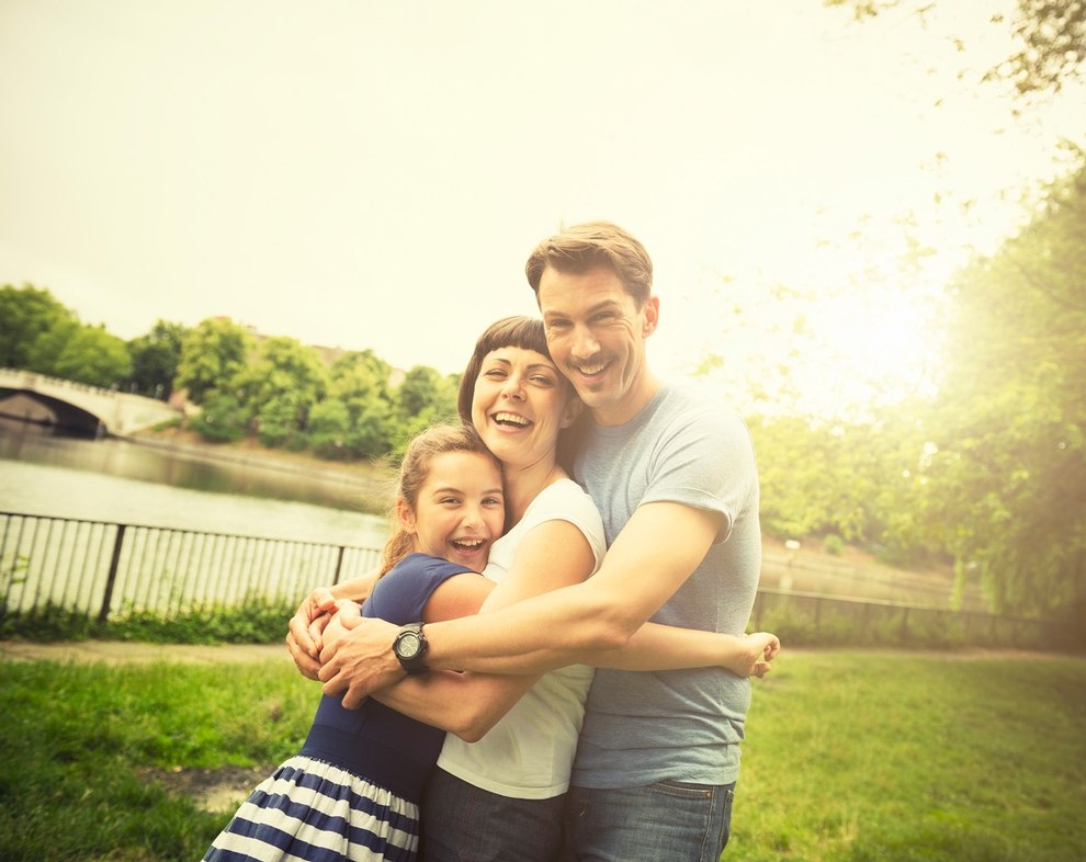 Mutter, Vater und Tochter umarmen sich