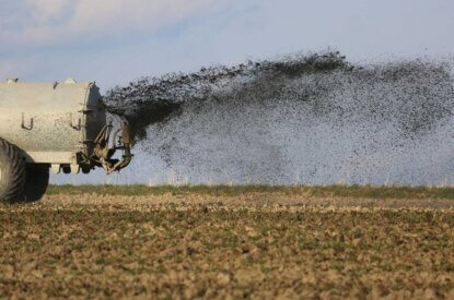 Feld wird mit Guelle geduengt