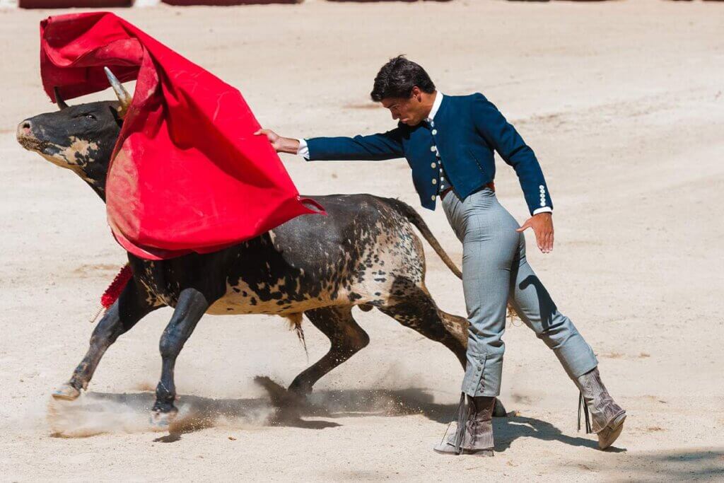 Matador wirft rotes Tuch nach einem Stier