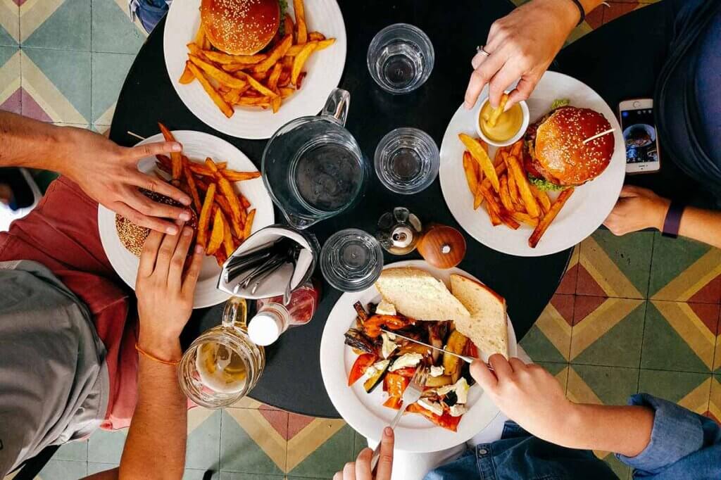 Menschen essen Burger am Tisch