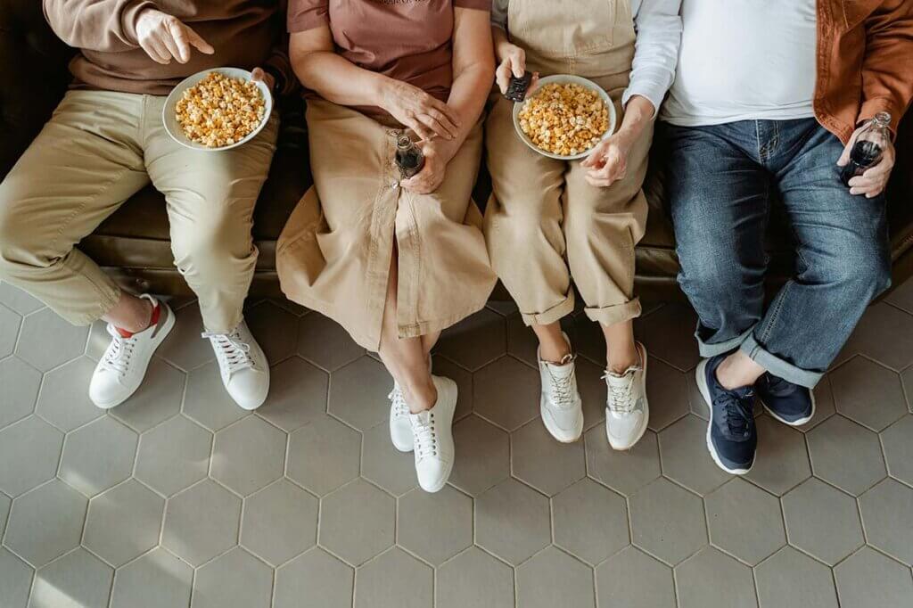 Menschen sitzen auf der Couch und essen Popcorn